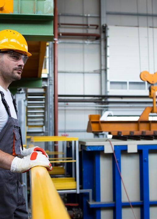 portrait-male-factory-worker-leaning-metal-railings-industrial-production-hall_342744-86